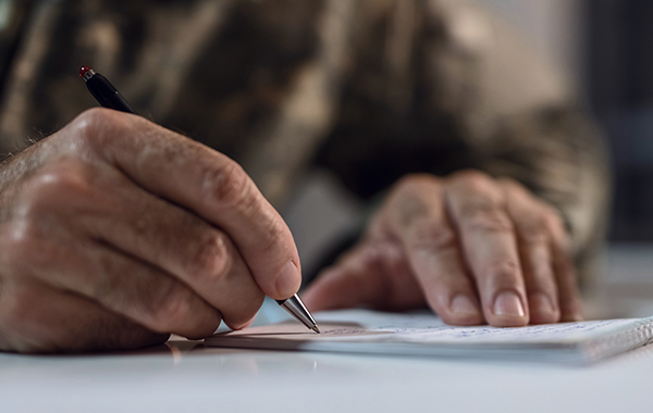 Feature-feedback (Close up of someone writing on a notepad)
