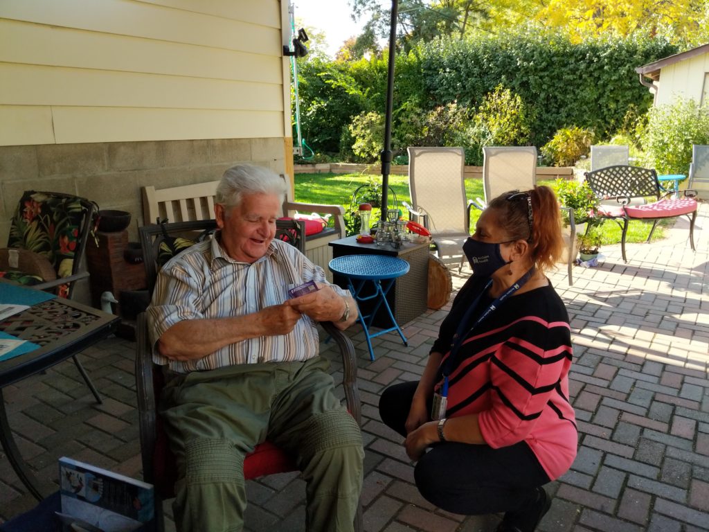 Acclaim Health staff member bringing Peter his activity care package in their Burlington backyard.